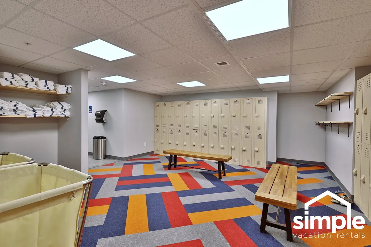 This image shows a casual locker and bench area with colorful carpet, wooden benches, and storage options. It's a spot where guests prep for or unwind after activities, suggesting transitions to and from outdoor adventures.