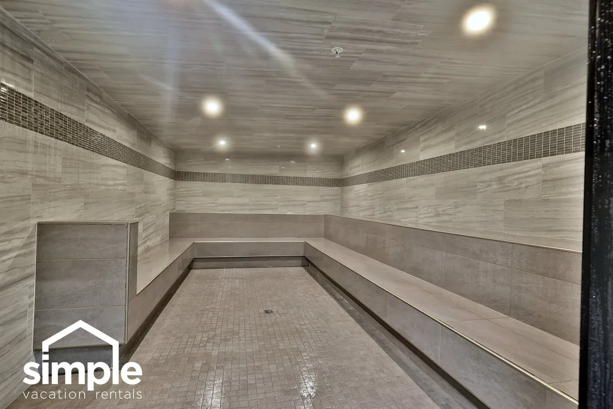 A serene relaxation and wellness lounge with smooth tile surfaces, linear seating, and soft ambient lighting, creating a tranquil atmosphere perfect for unwinding after a workout or outdoor adventure.