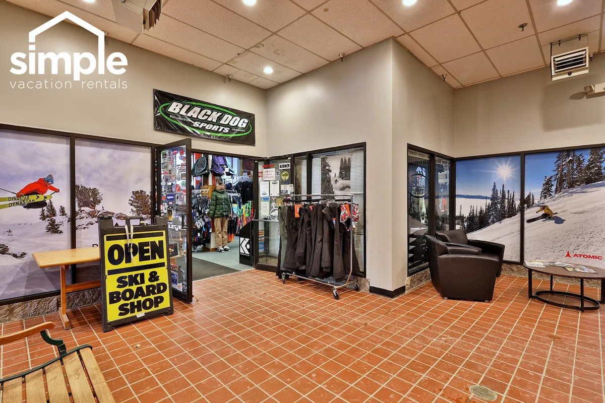 This interior image features the entrance to the ski shop, with ski and snowboard equipment prominently displayed and clear signage inviting guests in. The active, energetic vibe hints at the ease of renting or purchasing gear on-site, a key amenity for guests eager to hit the slopes.